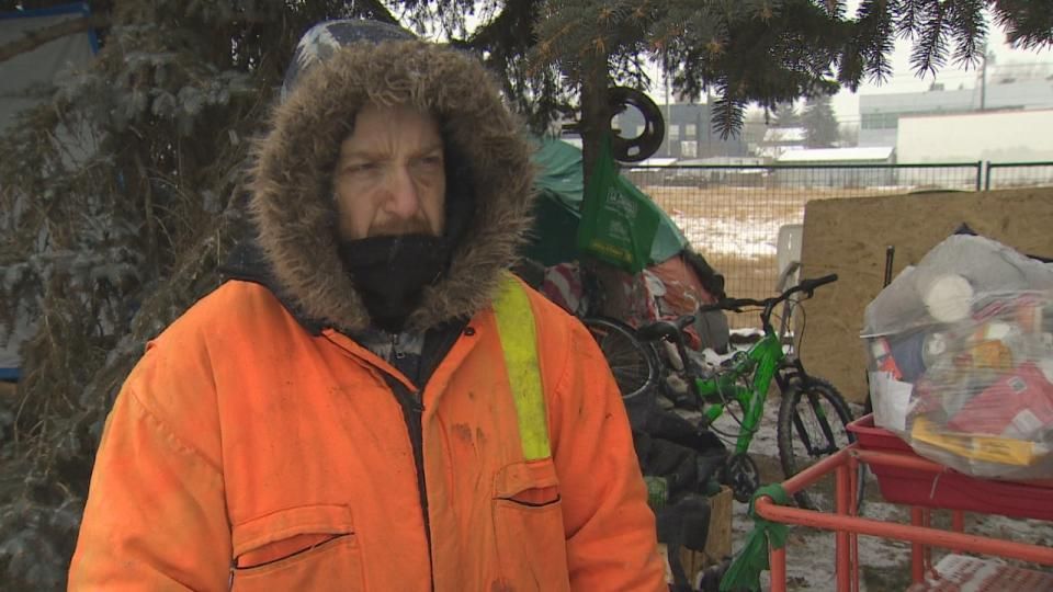 Anson Palmer visits a friend's campsite on Gateway Boulevard. Palmer said he and his fiancée camp closer to Southgate Centre, and that this is his fourth winter living on Edmonton's streets. (Craig Ryan/CBC - image credit)