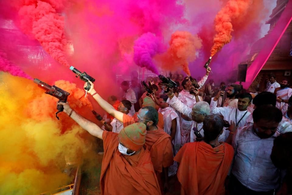 Hindu priests use colour smoke guns to celebrate Holi, the festival of colours, at a temple premises in Salangpur, in the western state of Gujarat, India, March 7, 2023.