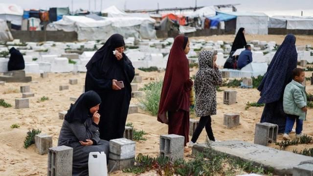 نساء فلسطينيات يزورن قبور أقاربهن الذين قتلوا خلال الحرب في غزة، في مقبرة برفح (10 نيسان/أبريل 2024)