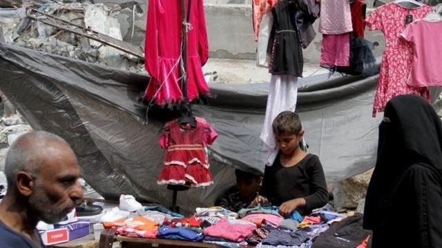 فتى يعمل في كشك لبيع ملابس عيد الفطر شمال قطاع غزة (9 أبريل 2024)