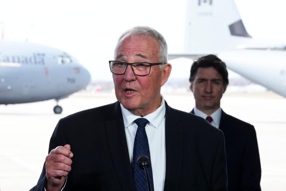 Prime Minister Justin Trudeau stands behind National Defence Minister Bill Blair as they hold a press conference on Canada's new defence policy at CFB Trenton in Trenton, Ont. on Monday, April 8, 2024. (Sean Kilpatrick/The Canadian Press - image credit)