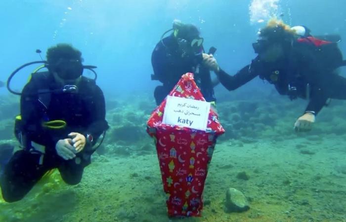 غواصة مصرية تحمل فانوسًا كبيرا للتهنئة برمضان من قاع البحر الأحمر