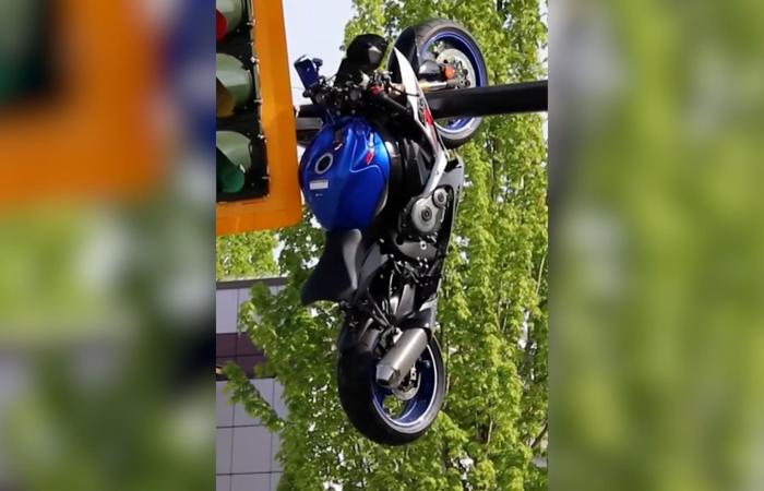 مشهد صادم.. دراجة نارية تتدلى من عمود إشارة مرور بعد حادث تصادم