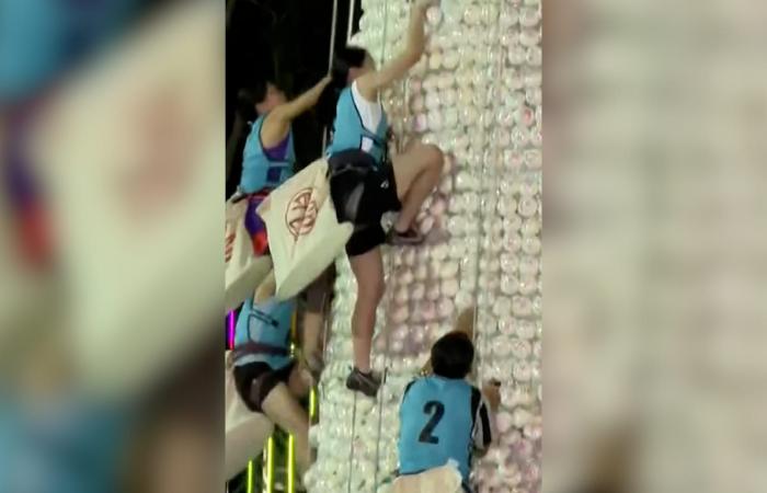 شاهد.. متنافسون يتسلقون قمة برج شاهق زُين بالكعك البلاستيكي